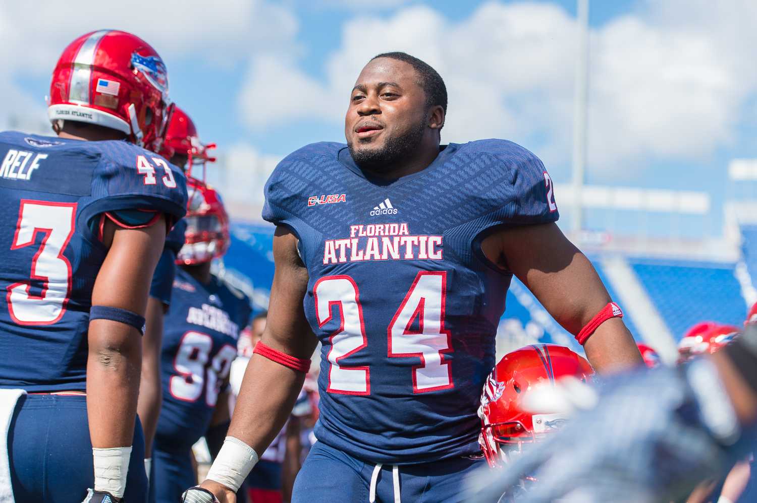 FAU senior running back Tony Moore walks through the human tunnel of teammates during the Senior Day Celebration prior to the game.  