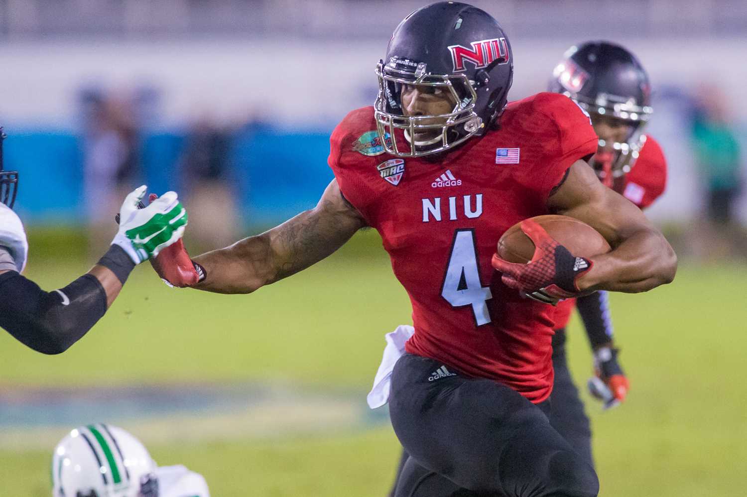 Da'Ron Brown (4) of the Northern Illinois Huskies throws a stiff arm to pick up yards in the second half of the Boca Raton Bowl. 