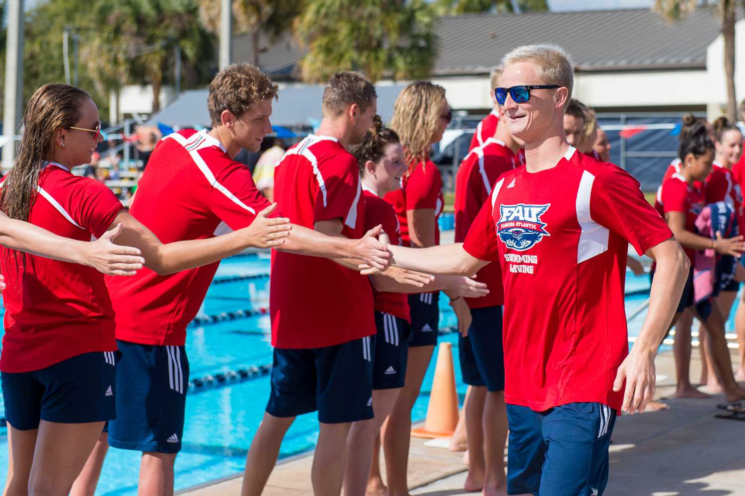 Team captain Richard Andrews (right) from FAU high-fives his teammates during the senior send-off ceremony prior to the start of the meet.  Andrews won the men’s 200 freestyle with a time of 1:42.17.