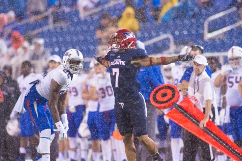 Defensive Back Cre'von LeBlanc stretches his arms out in the rain during last year's game versus Tulsa. Photo by Max Jackson
