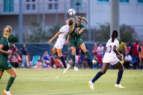 Senior midfielder Claire Emslie (9) jumps for a header against Miami redshirt junior defender Shannon McCarthy (8) during the first half of Friday’s Game. Emslie had an assist on the final goal of the 3-1 win. Photo by Brandon Harrington|Contributing Photographer