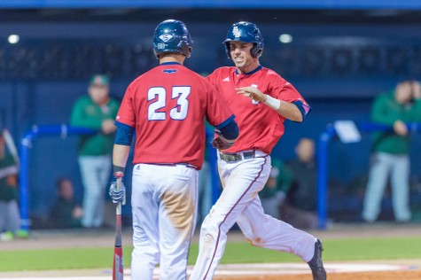 Junior shortstop C.J. Chatham is greeted at the plate by then senior outfielder Brendon Sanger (23) during the Owls’ 5-3 win over the Miami Hurricanes on Feb. 18, 2015. Photo by Max Jackson | Staff  Photographer