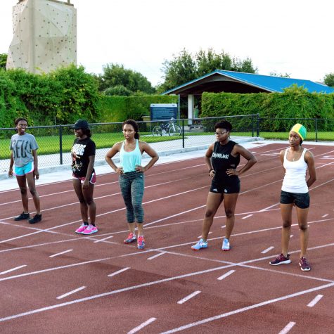 Participants in the Women's 100 meter race line up before the start of the event. Patrick Delaney | Photo Editor
