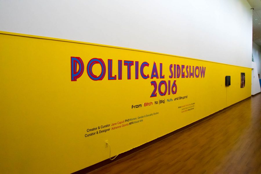 FAU’s Gender and Women’s Studies Professor and “Political Slideshow 2016” curator/creator Jane Caputi Poses for a photo with her favorite piece from the election exhibit. Craig Ries | Contributing Photographer
