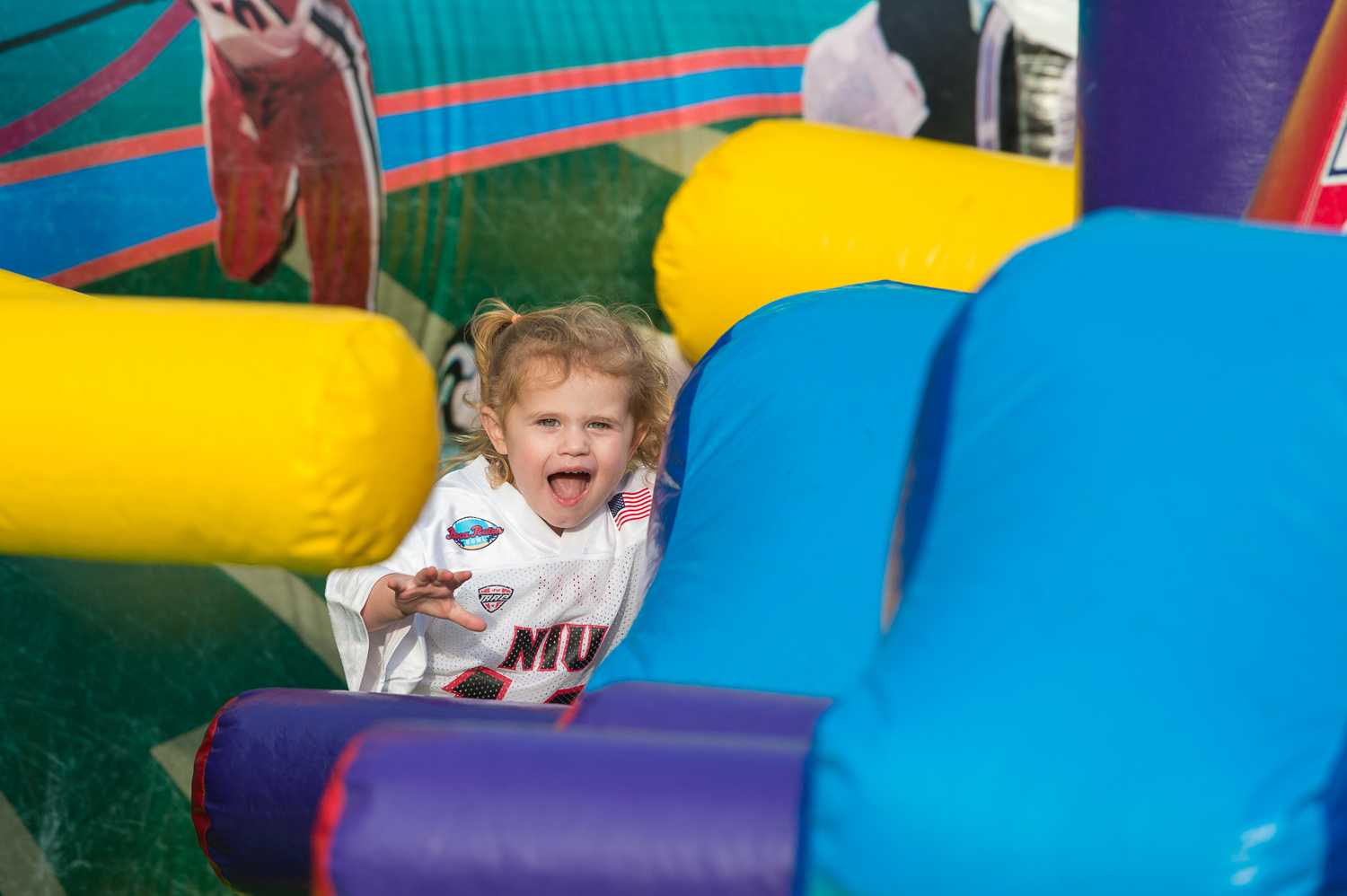 During the pre-game festivities outside of FAU Stadium, Morgan Harmon runs through an inflatable football game.  The Harmon family traveled to Boca Raton from DeKalb, Illinois to cheer on the Huskies. 