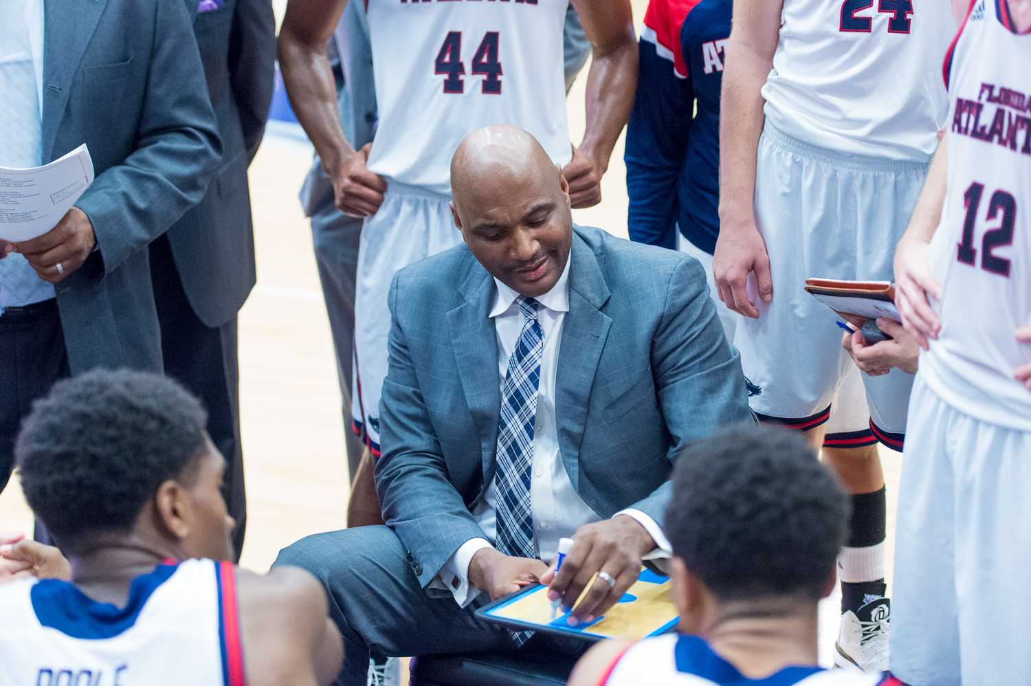 FAU head coach Michael Curry goes over a play with his team during a timeout in the second half of play. 