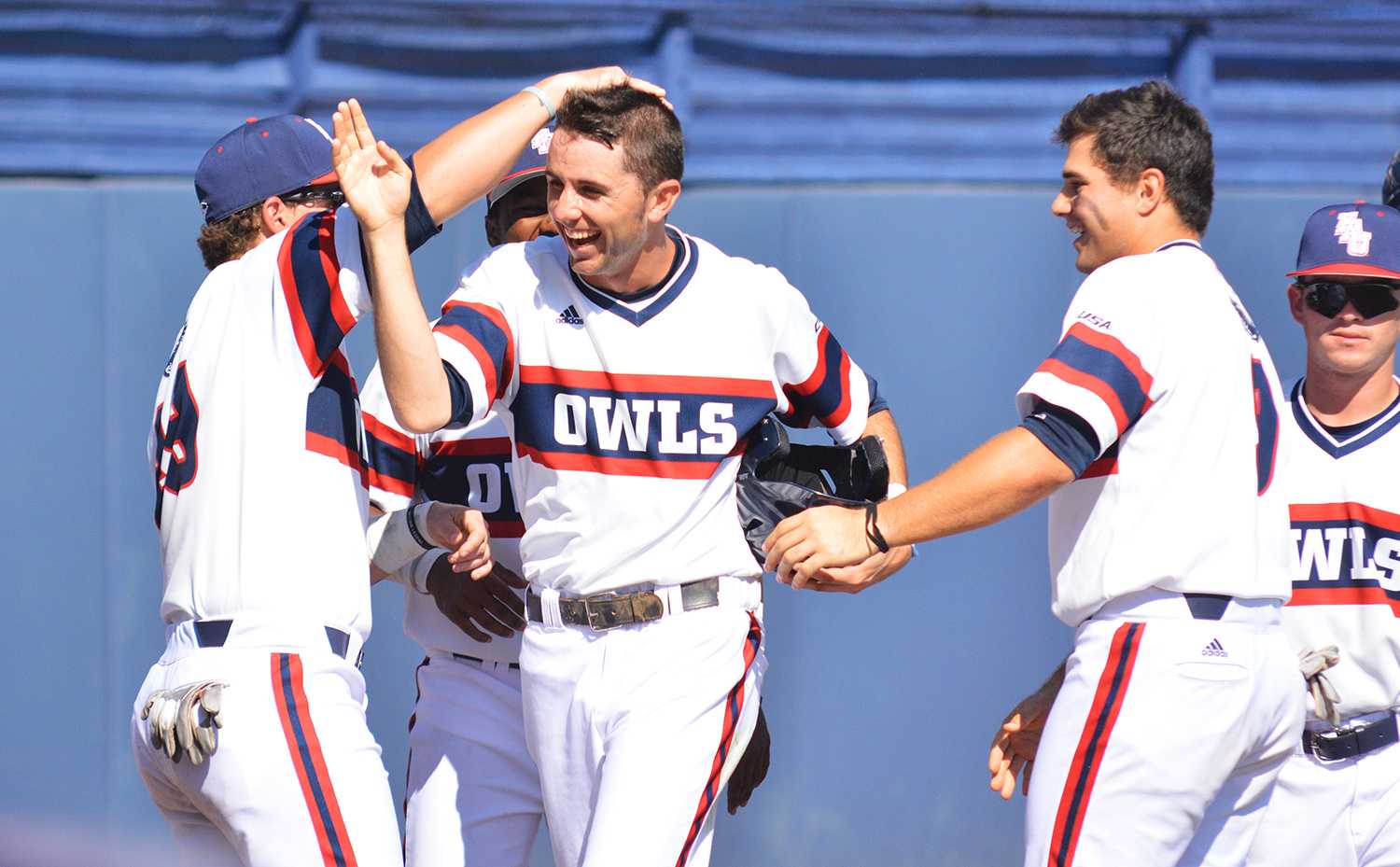 Sophomore infielder CJ Chatham is greeted by teammates after being driven in by Brett Lashley single in the sixth inning of the third game. Chatham scored one of the  Owls’ five runs that game. 