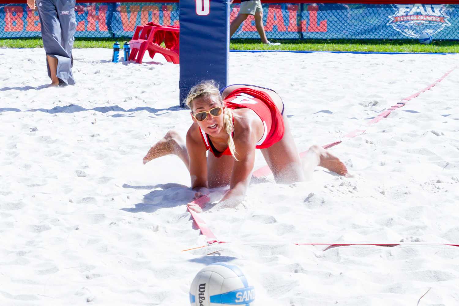 Junior Lexi Rhein (4) dives into the sand to try and keep the ball in bounds