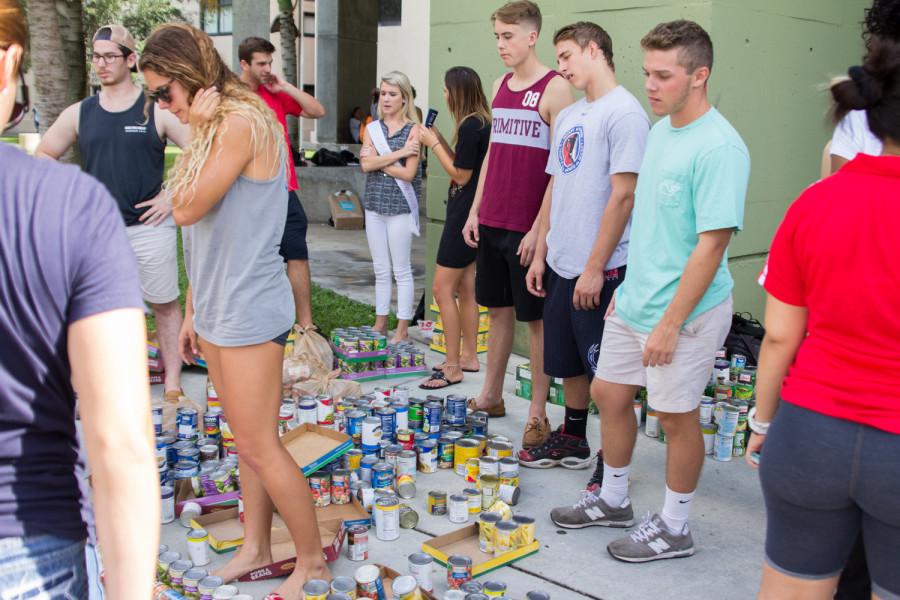 Students try to build a superhero sculpture out of canned goods to celebrate 2015s Homecoming theme Agents of Change. Photo courtesy of Charles Pratt
