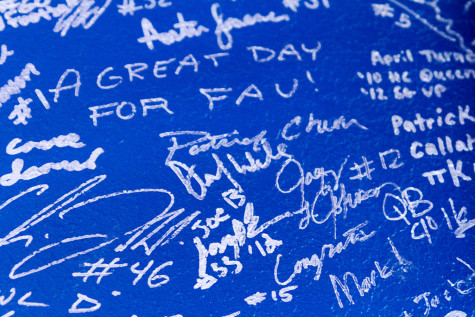 The front wall of the store is covered in the signatures of FAU athletes. Photo by Jasmyn Williams.