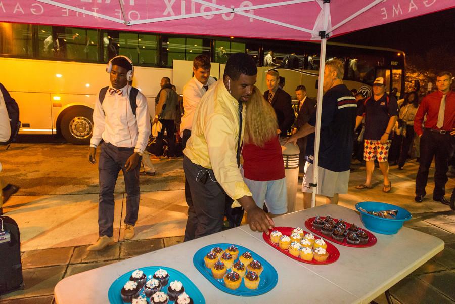 Quarterback Jaquez Johnson returning after a football game, welcomed warmly with cupcakes. Photo by Max Jackson
