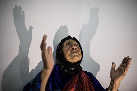 A displaced Iraqi Christian woman prays at the home where she is staying in Erbil. Photo courtesy of Mackenzie Knowles-Coursin for The United States Holocaust Memorial Museum