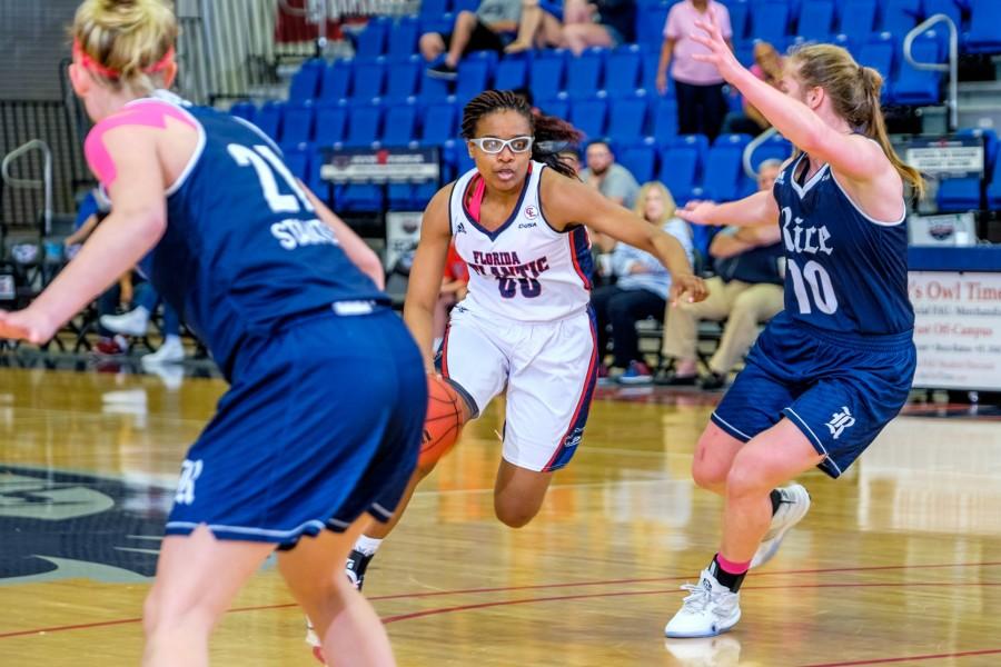 Owl’s sophomore guard Danneal Ford (00) tries to dribble past Rice’s Wendy Knight

(10) towards the basket during FAUs Mohammed F Emran | Staff Photographer