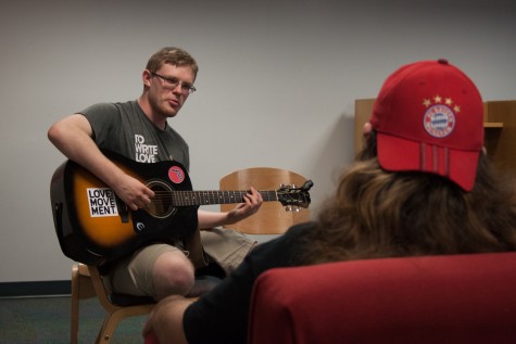 Chapter president Andrew Archibald playing guitar while wearing a T-shirt that bears the organization’s name. Joshua Stoughton | Contributing Writer