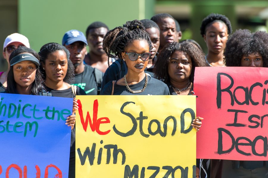 Berlinie St. Fort, junior communications major (center) shows her support for students at
the University of Missouri during a protest in November 2015. Some other signs said “Racism isn’t dead,” and “#indictthesystem
Black and Proud.”. Max Jackson | Staff Photographer
