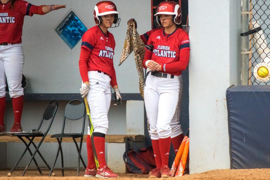 Christina (left) and Melissa Martinez wait in the dugout for their respective turns at bat. Ryan Lynch | Multimedia Editor