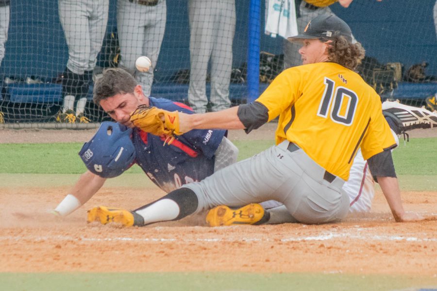 Junior shortstop CJ Chatham slides safely past the tag of University of Southern Missippi senior pitcher Jake Winston after a passed ball in the bottom of the sixth inning of the teams April 30 game. Ryan Lynch | Multimedia Editor