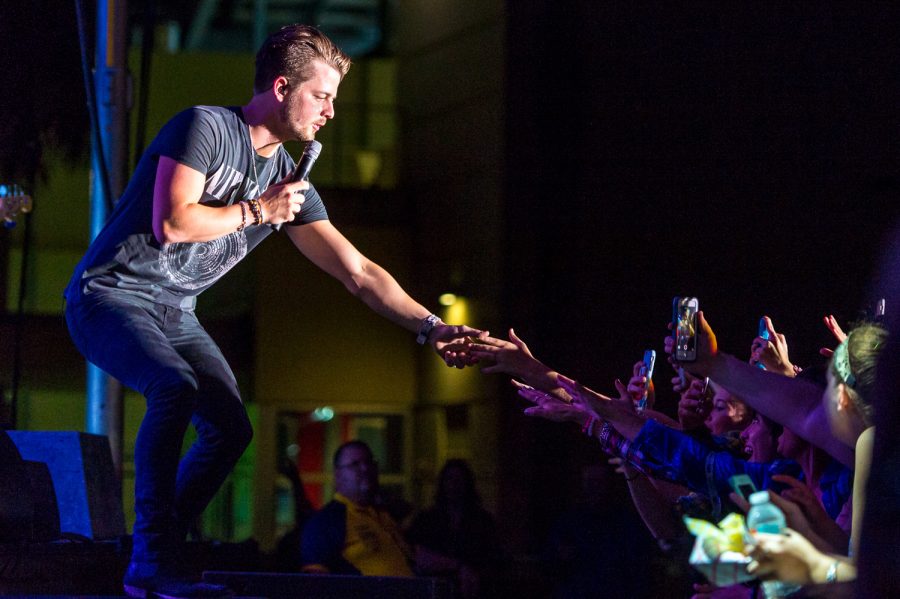 Chase Bryant reaches out and touches the hand of a fan during the FAU bonfire concert on Monday evening. Max Jackson | Staff Photographer