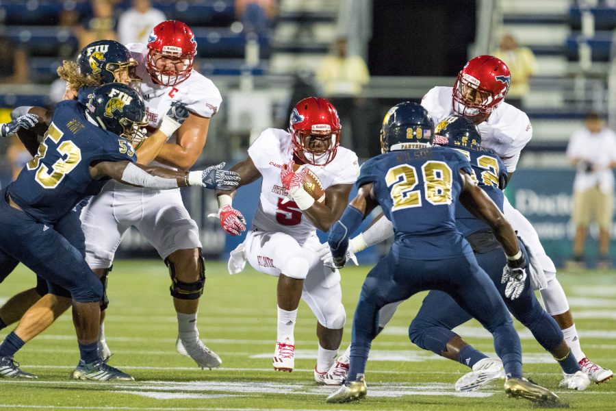 FAU freshman running back Devin Singletary (5) stares down FIU senior safety Deonte Wilson (28) as he rushes down the center of the field. Singletary rushed for 86 total yards against FIU Saturday night. Brandon Harrington | Staff Photographer