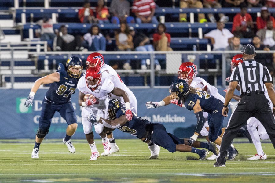 FAU freshman running back Devin Singletary (5) shakes off a tackle attempt by FIU junior linebacker Anthony Wint (53). Singletary scored one touchdown against FIU in the Shula Bowl. Brandon Harrington | Staff Photographer