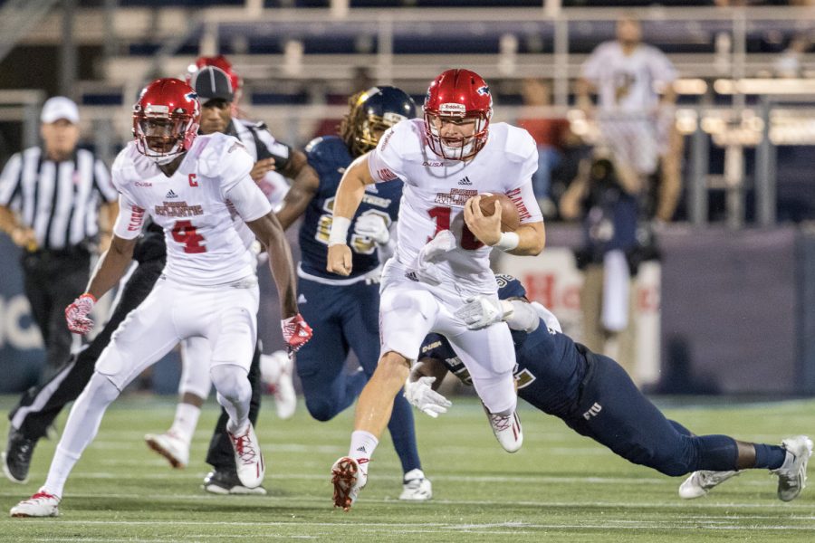 FAU sophomore quarterback Jason Driskel (16) runs the ball to gain a first down early in the first quarter. Although Driskel rushed 49 yards, FIU won the game 33-31. Brandon Harrington | Staff Photographer