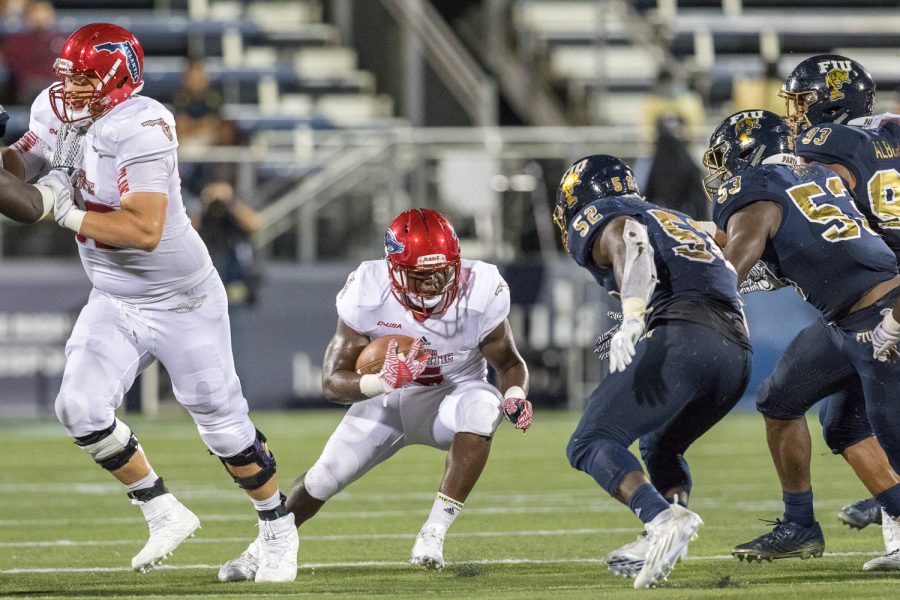 FAU freshman running back Devin Singletary (5) avoids being tackled by three FIU defenders in the first half against FIU in the Shula Bowl Saturday night. Brandon Harrington | Staff Photographer