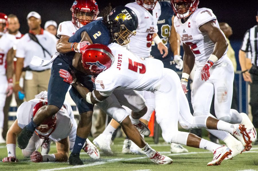 Owls defensive back DJ Juste (5) takes down FIU running back Anthony Jones (2). Max Jackson | Staff Photographer