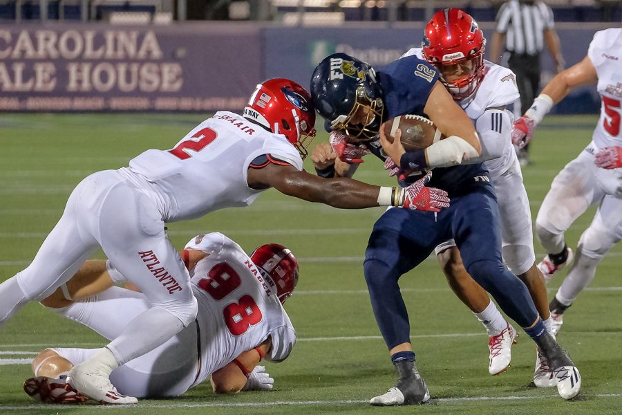 FAU linebacker Azeez Al-Shaair (2) tackles FIU quarterback Alex McGough (12). McGough gained enough yards for a first down on the play. Mohammed F Emran | Staff Photographer