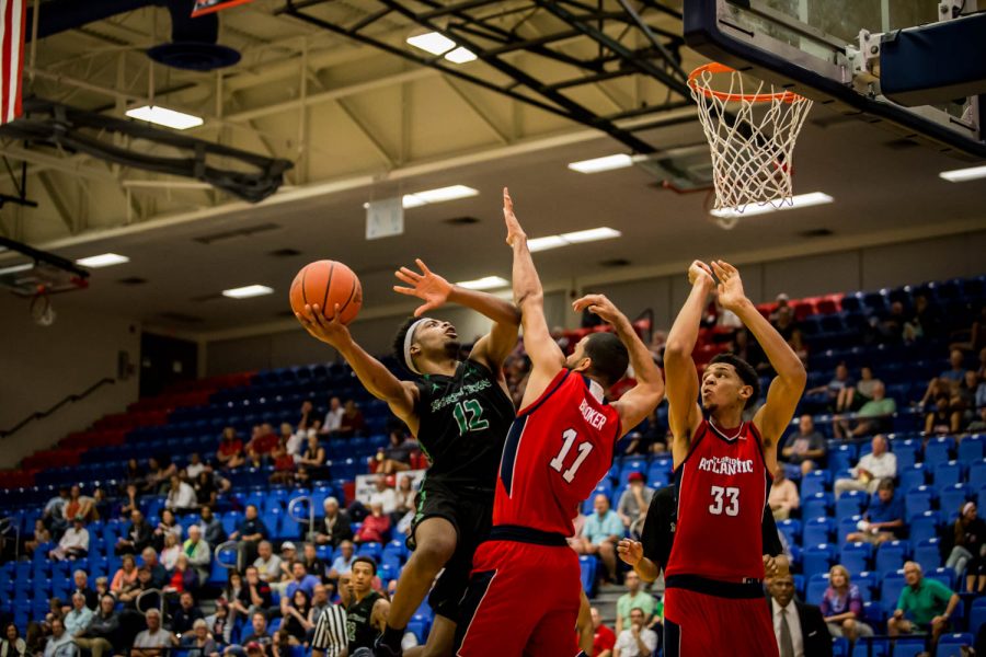 North Texas freshman A.J. Lawson goes up for a layup over FAU juniors Frank Booker (11) and Ronald Delph during the Owls 70-64 loss Thursday. Alexander Rodriguez | Contributing Photographer