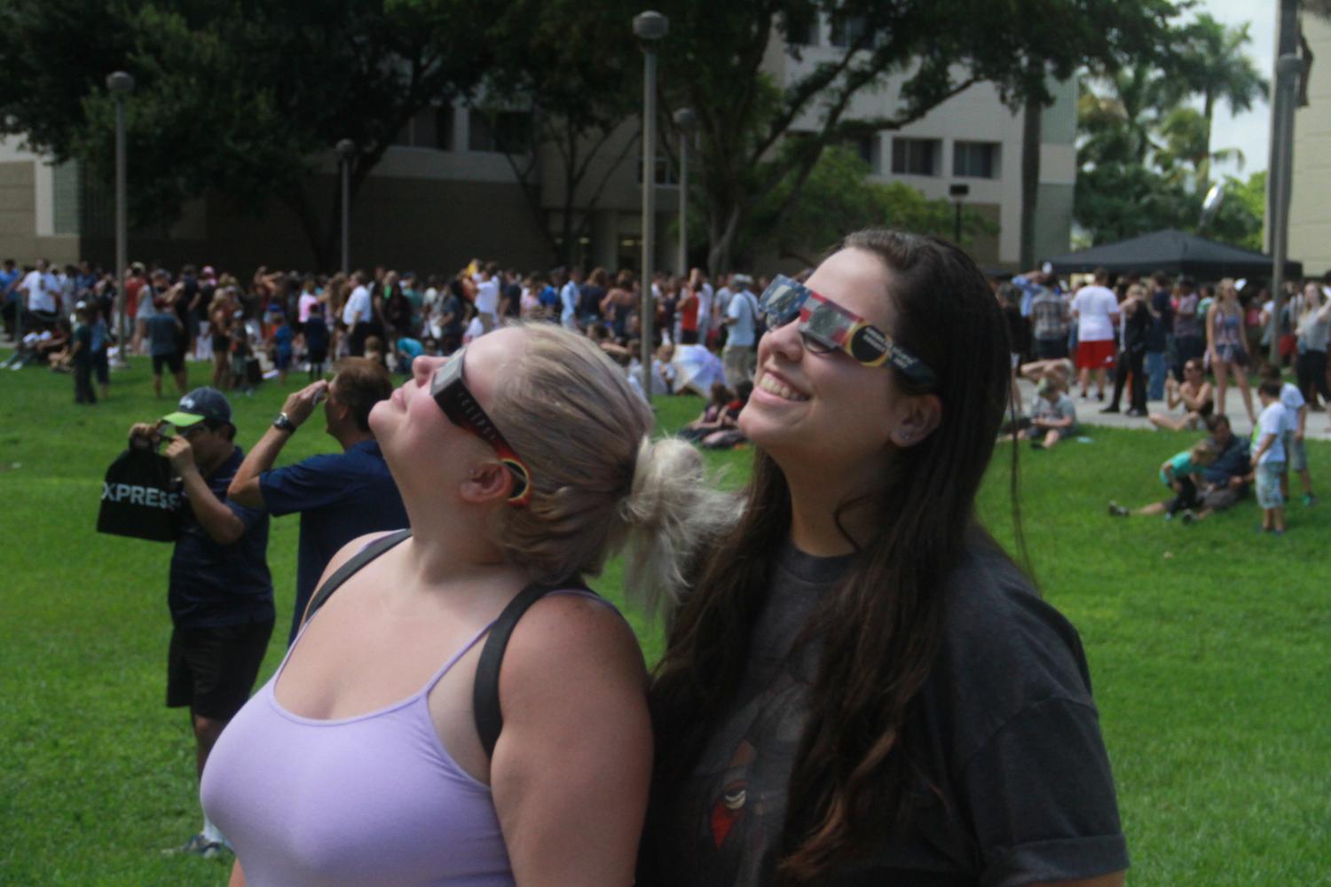 Junior communications major Cassandra Penrod (left) and junior elementary education major Leyla Massaro take a look at the solar eclipse with their eclipse glasses. Photo by Joe Pye | Editor in Chief