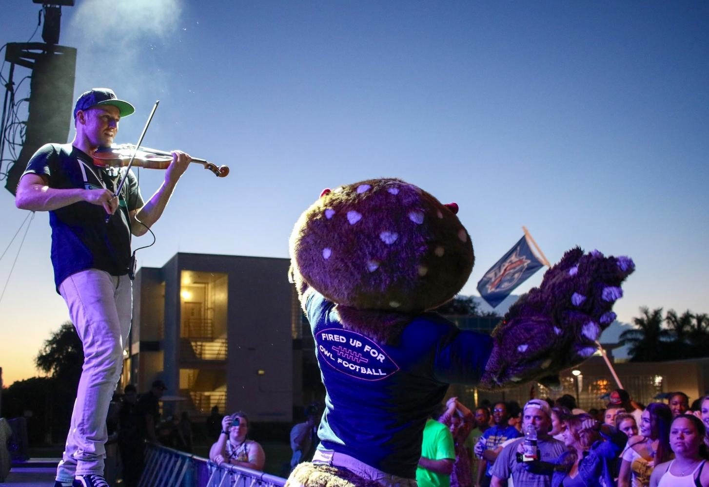 FAU’s mascot Owlsley helps the opening act, hip-hop violinist Josh Vietti, get the crowd dancing during his performance. Joshua Giron | contributing photographer.