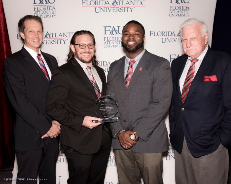 (Left to right) President John Kelly, former football players Kris Bartels and Cergile Sincere, head coach Howard Schnellenberger. Photo courtesy of Jeffrey Tholl Photography