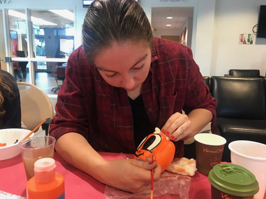 Desiree Cancel, a junior majoring in psychology, paints a pumpkin at Owlcraft. Thomas Chiles | Features Editor