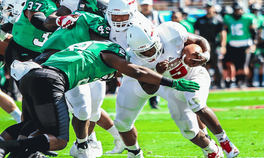 FAU sophomore running back Devin Singletary (5) rushes toward a North Texas player to gain some yardage during the first quarter. FAU went on to win 41-17 against North Texas for the C-USA Championship on Dec. 2. Alexander Rodriguez | Photo Editor