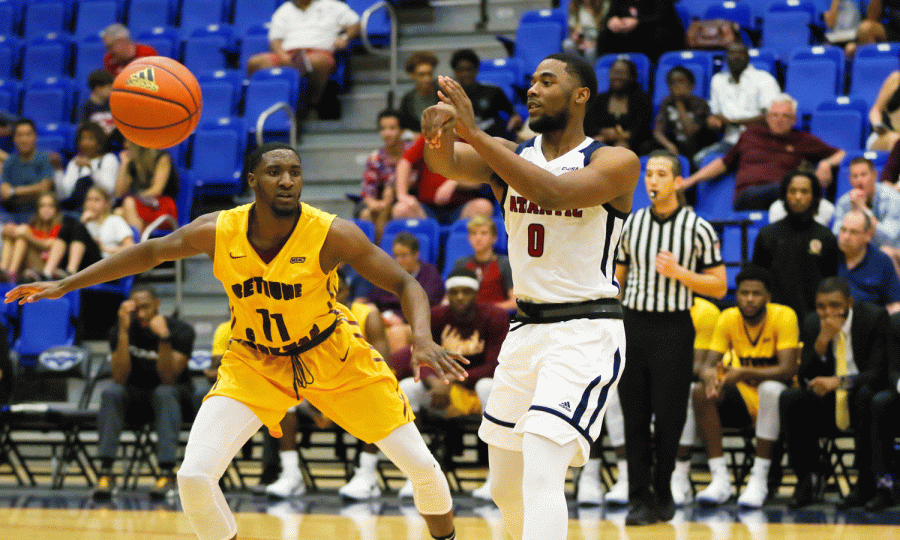 FAU graduate student guard Payton Hulsey (0) makes a pass across the court while Bethune-Cookmans Soufiyane Diakite (11) guards him. FAU went on to win 93-75 against Bethune-Cookman on Dec. 2 at FAU Arena. Joshua Giron | Staff Photographer