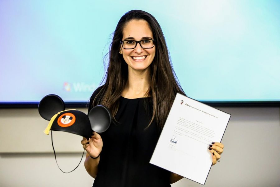 Jennifer Berman, assistant director for internships and account manager for Disney College Program, holds her mickey mouse ears and the certificate from Disney that says FAU is a “distinguished college institute” when it comes to hiring FAU students for the program. | Alexander Rodriguez