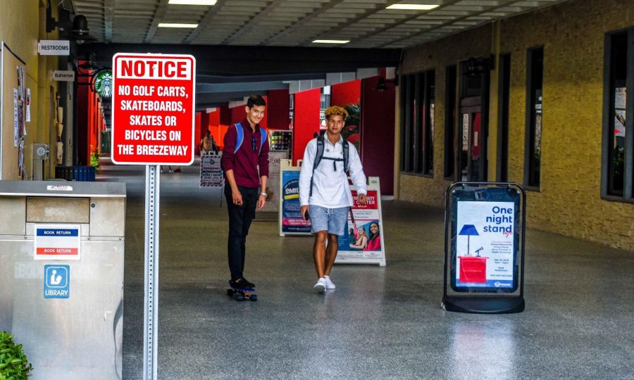 Despite signs prohibiting skateboarding in the Breezeway, a student rides his board toward the entrance near the food court. Anthony Joe Washko | Contributing Photographer 