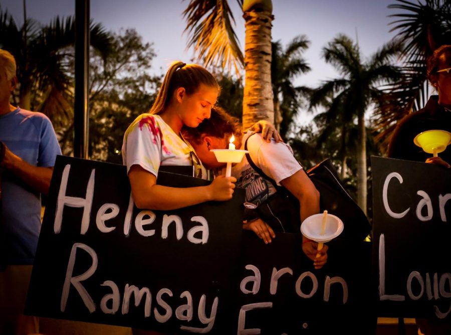 22-year-old graduate student Tori Sletzer, left, holds her friend Taylor Miller, a junior elementary education major, right, during a prayer at the candlelight vigil. Both students attended Marjory Douglas High School and knew the football coach, Aaron Feis, who died shielding other students from gunfire. | Alexander Rodriguez
