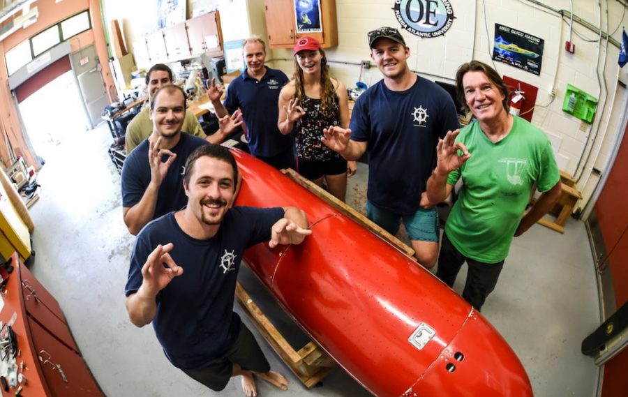 The Human Powered Submarine Club stands with their submarine in their workshop. Photo courtesy of the FAU News Desk 