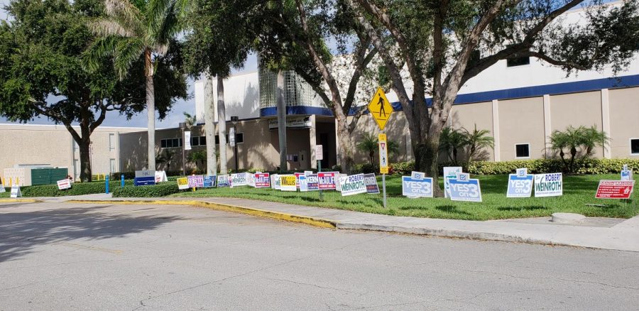 Flags advertising different candidates and amendments have been placed near the Housing office, where community members are now able to vote ahead of the Nov. 6 general election. Photo by Violet Castano