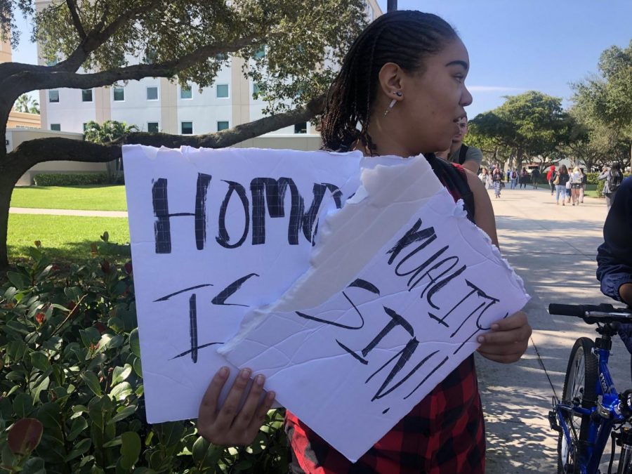 Sophomore English major Rihanna Davis holds up the mans sign that she stole and ripped in half. Photo by  Sophie Siegel 