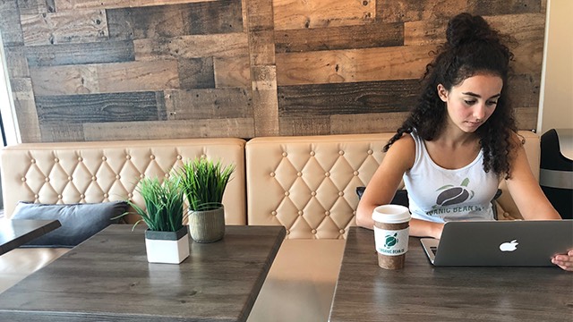 Tiffany Hakim working inside of Organic Bean Co., the coffee shop she opened almost a year ago. Photo courtesy of FAU