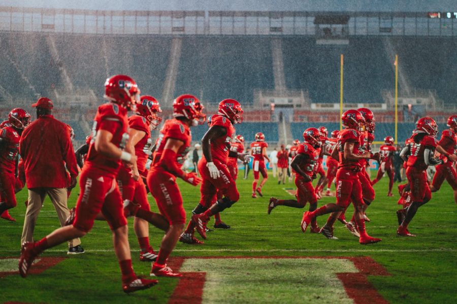 Florida Atlantic Football rushes the field to warm up in the midst of a downpour before the start of the Shula Bowl on Nov. 9, 2019. The Owls beat FIU 37-7. Photo by Alex Liscio.