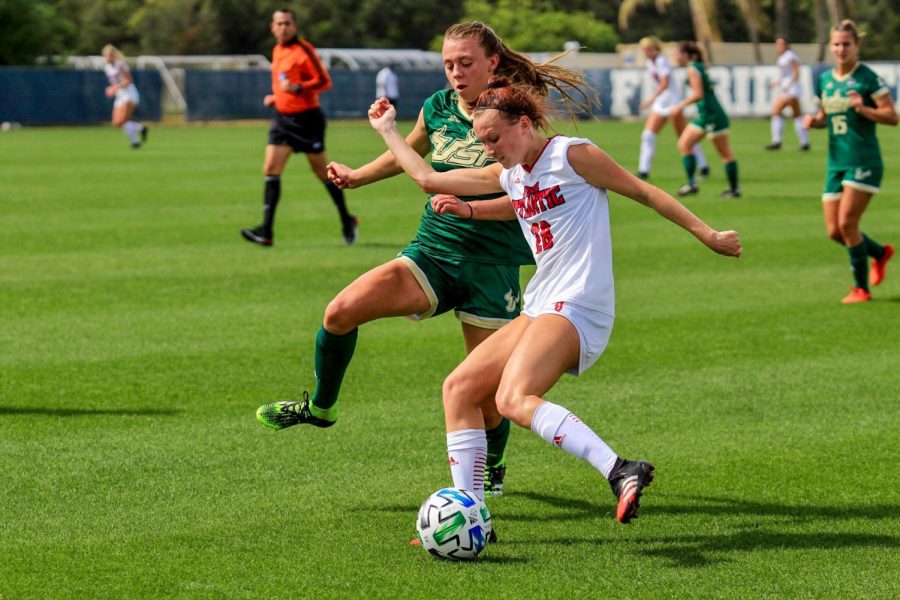Sammy+Vitols+%28pictured+white%2C+%2328%29+keeps+the+ball+away+from+the+USF+defender.+Photo+by+Eston+Parker+III.