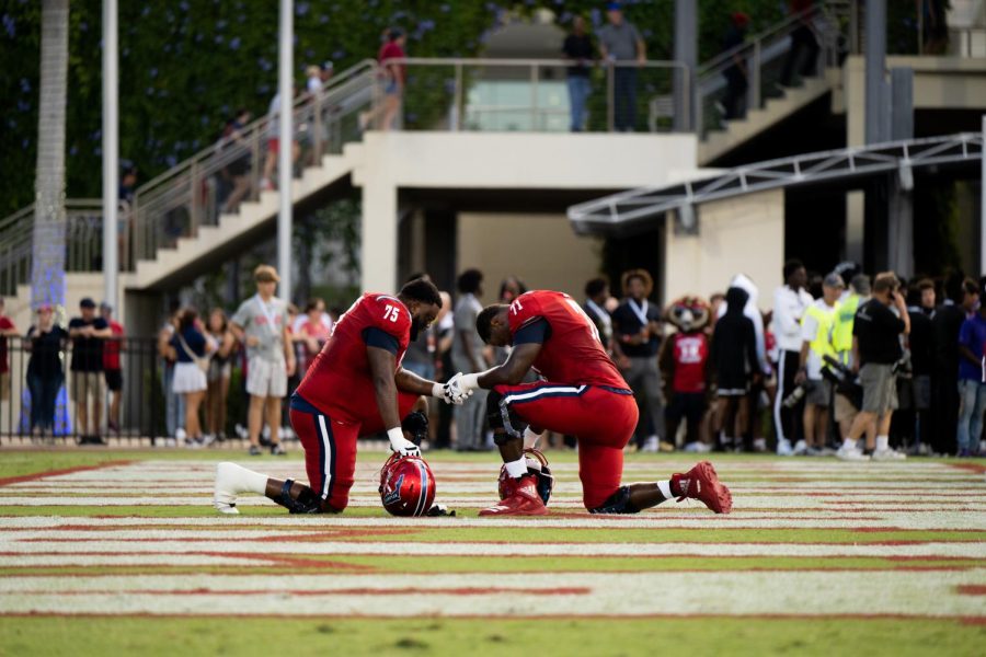 Marquice Robinson (left) and Chaz Neal (right) taking a knee before the game against Charlotte on August 27, 2022.