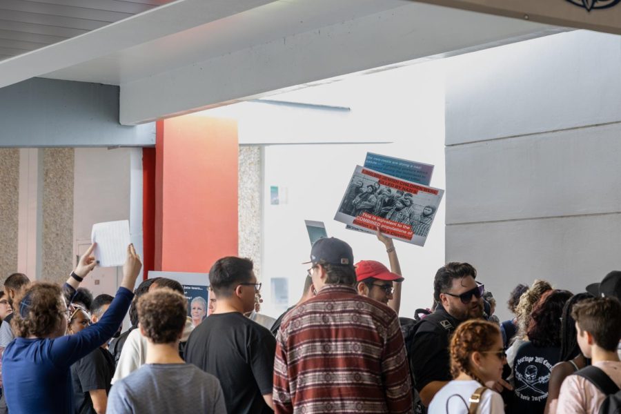 FAU Students crowding around “#YeisRight” table in opposition to their antisemitic ideas. Individuals hold signs with holocaust statistics and historic timelines.