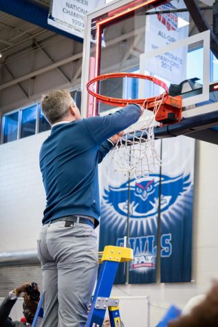 Head Coach Dusty May Cutting down the net after championship win on Feb. 25, 2023.