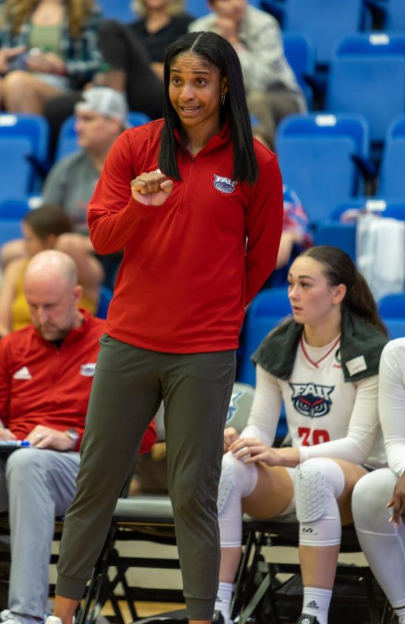 Jennifer Sullivan pictured coaching in a red quarter zip sweater.