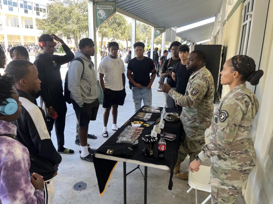 Sgt.+Jessica+McNeill+and+Senior+Sgt.+Devaughn+Williams+speaking+with+Atlantic+High+School+football+players+about+Army+opportunities+during+lunch+at+their+weekly+table+set+up.+Jan+12%2C+2023.+Courtesy+of+Jessica+McNeill.