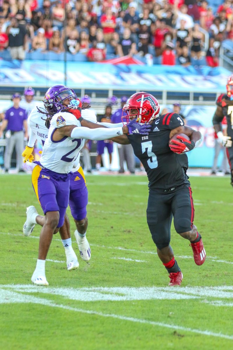 FAU senior running back Larry McCammon III (#3) stiff-arming a defender to get the first down during the Owls 22-7 loss to East Carolina at Howard Schnellenberger Field on Saturday, Nov. 11, 2023.
